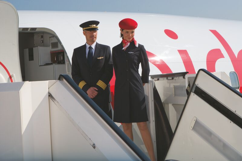 Stewardess und Kapitän erwarten die Reisenden
