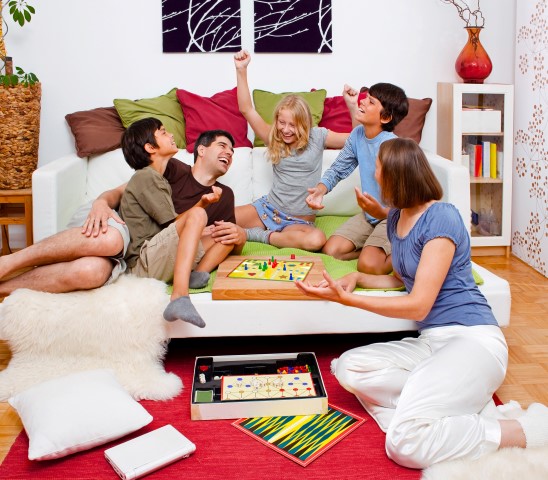 Eine Familie spielt Spiele am Tisch im Wohnzimmer