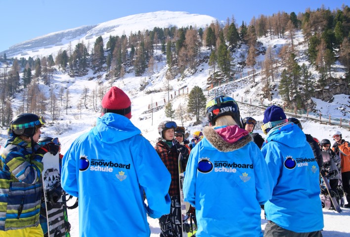 Snowboardleher erklären den Schülern die Grundlagen des Snowboardens
